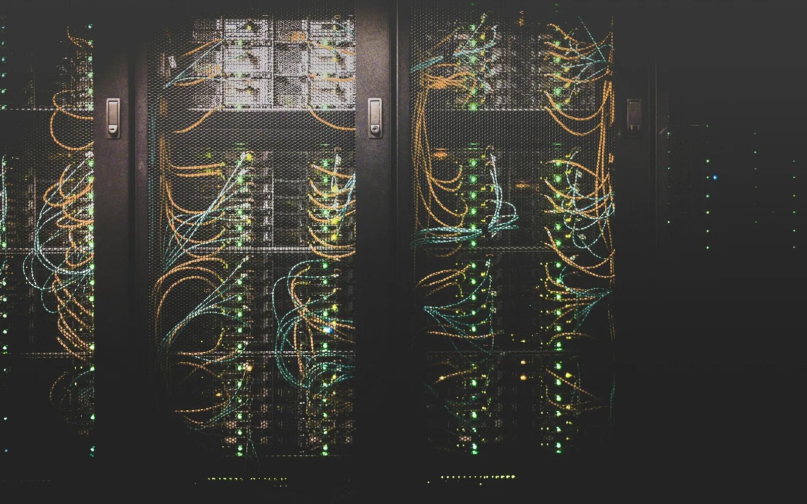 Server racks with network cables in a dark room