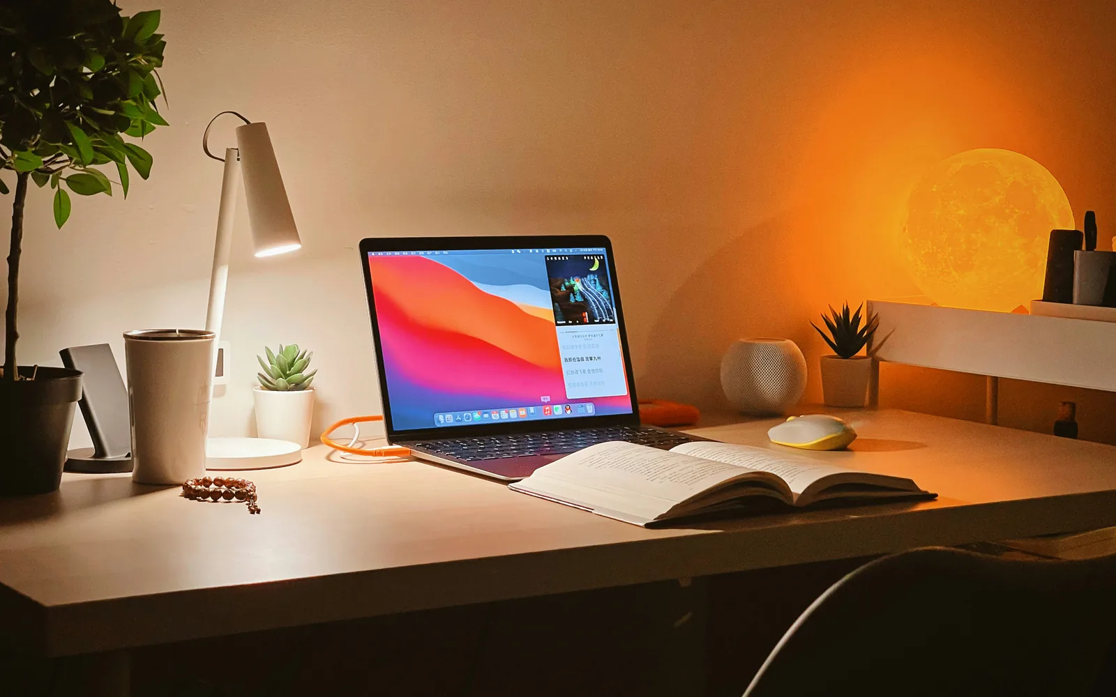 Laptop on a desk lit by a warm lamp