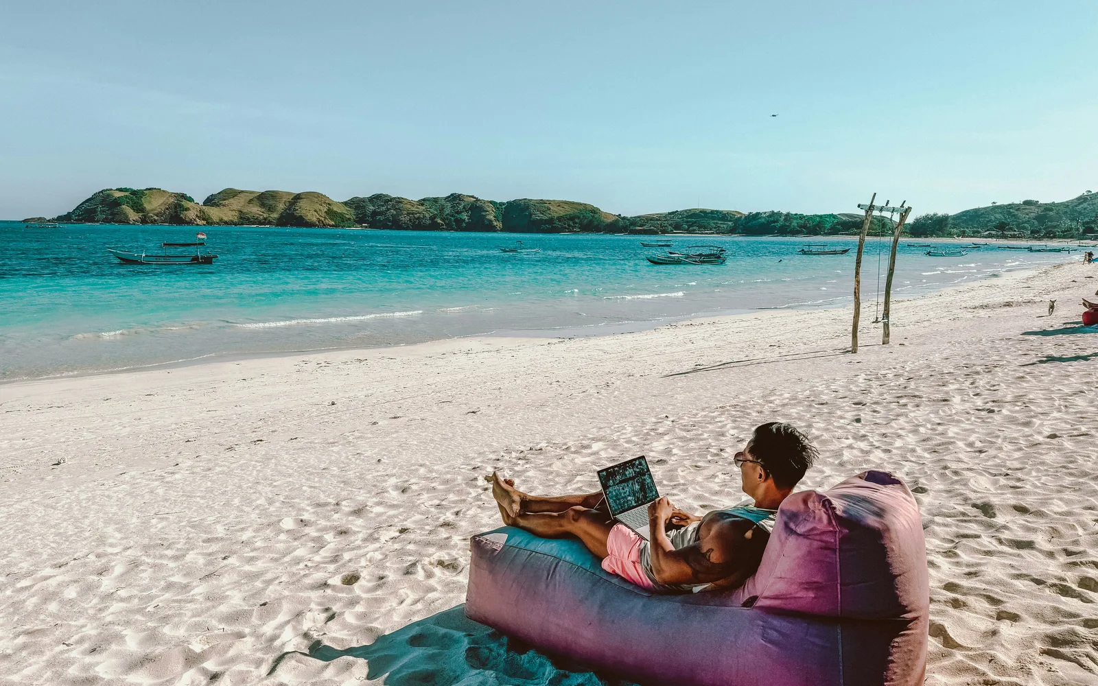 a man sitting on a bean bag on the beach