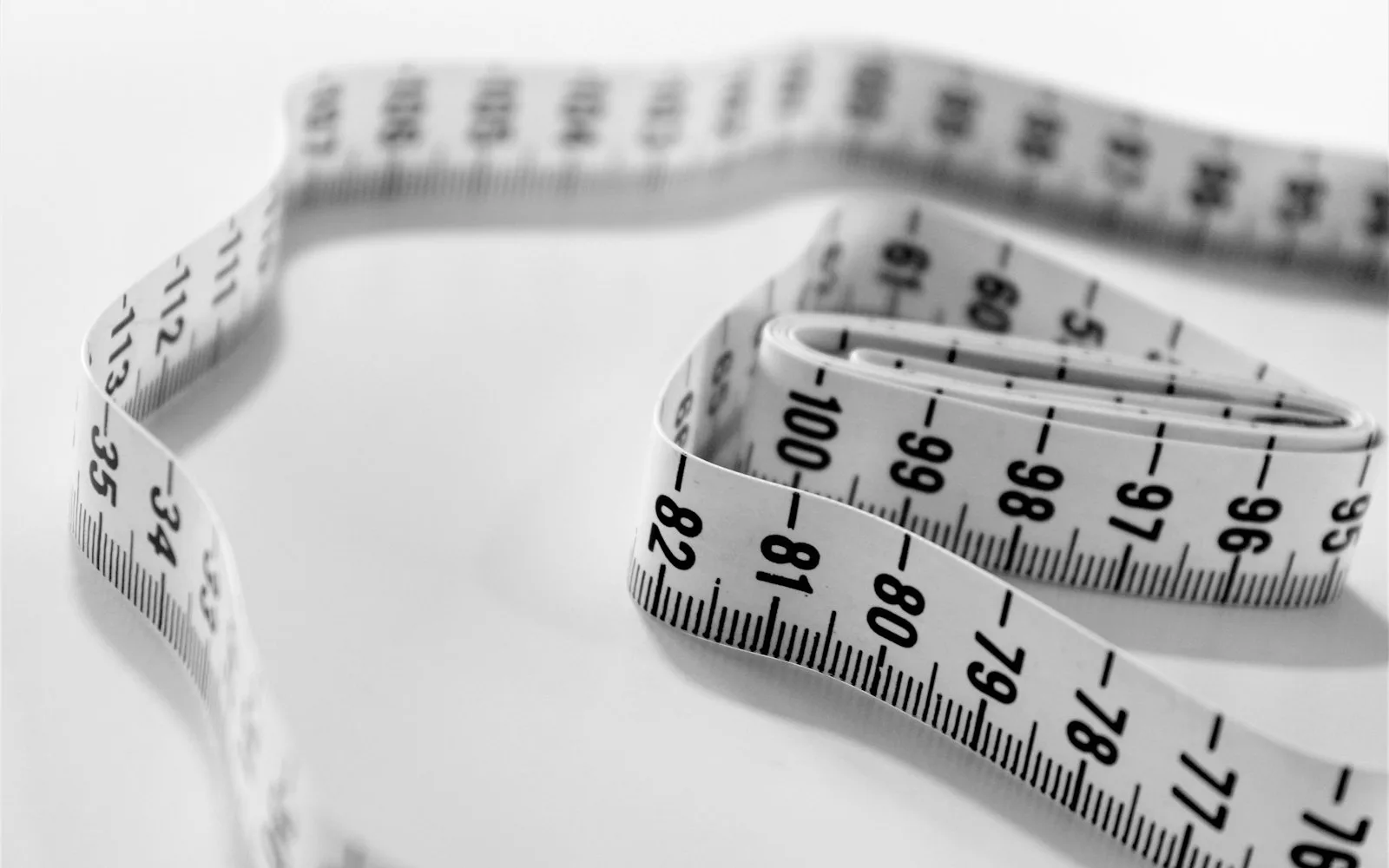 A cloth tape measure in selective focus, most of its length blurred.