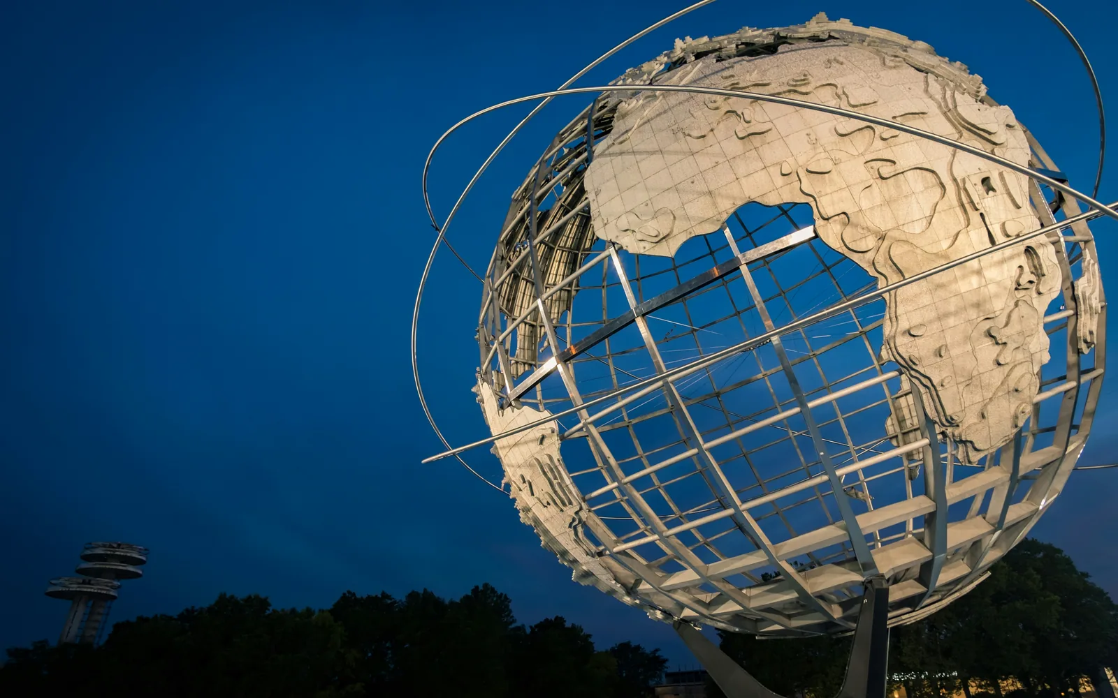 Steel globe sculpture against a dusk sky