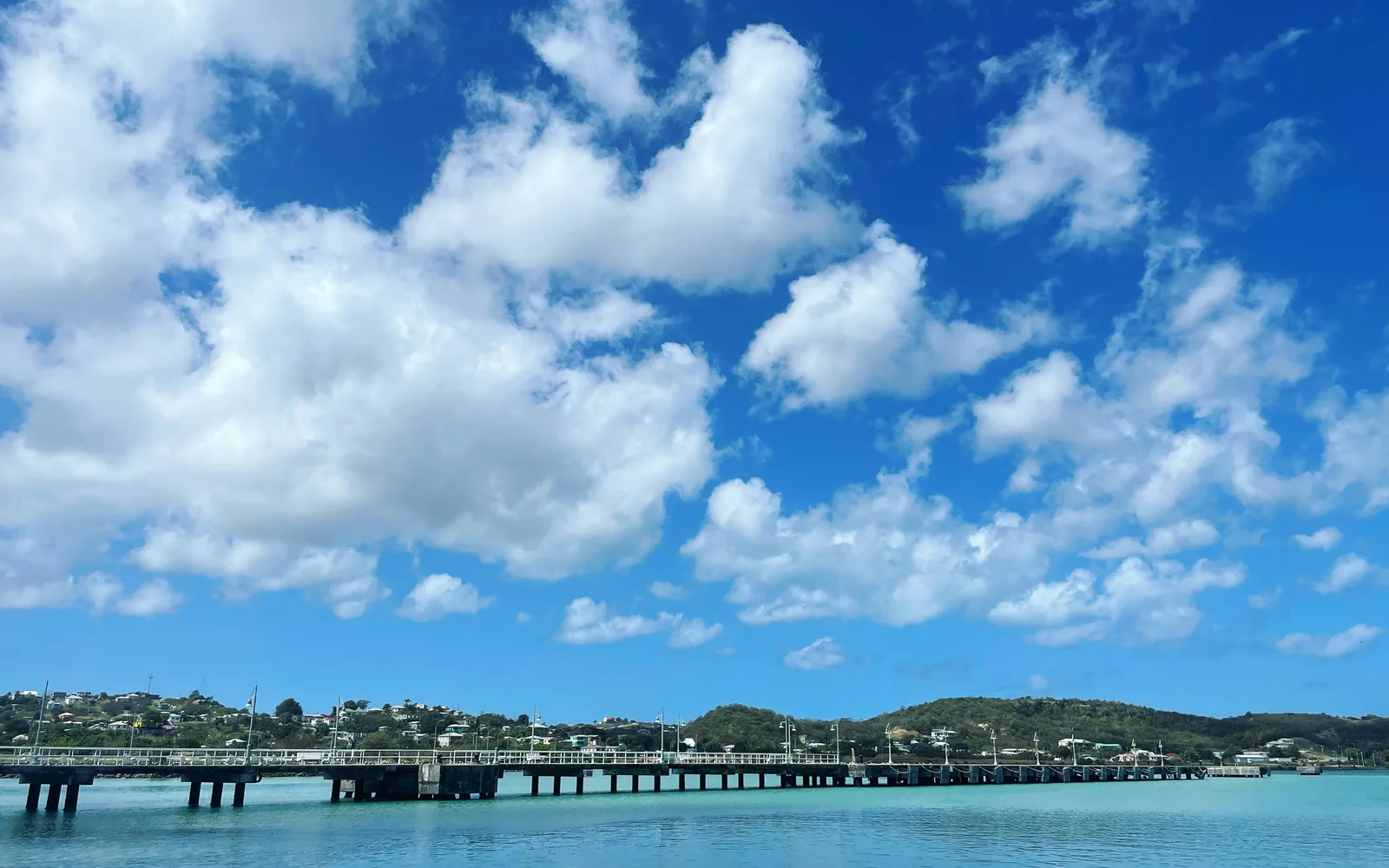 a bridge over a body of water under a cloudy blue sky