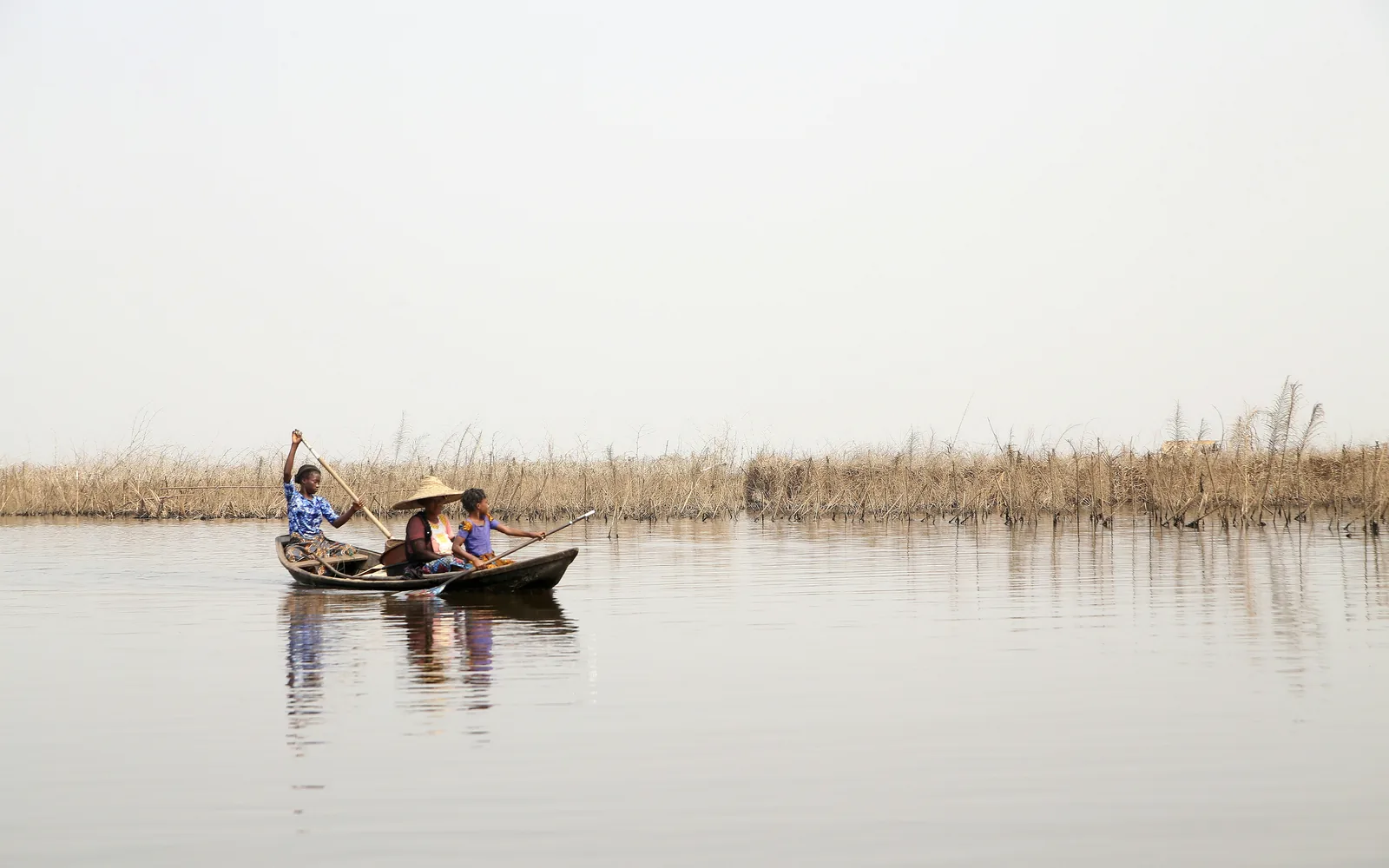 man riding on blue boat on body of water during daytime