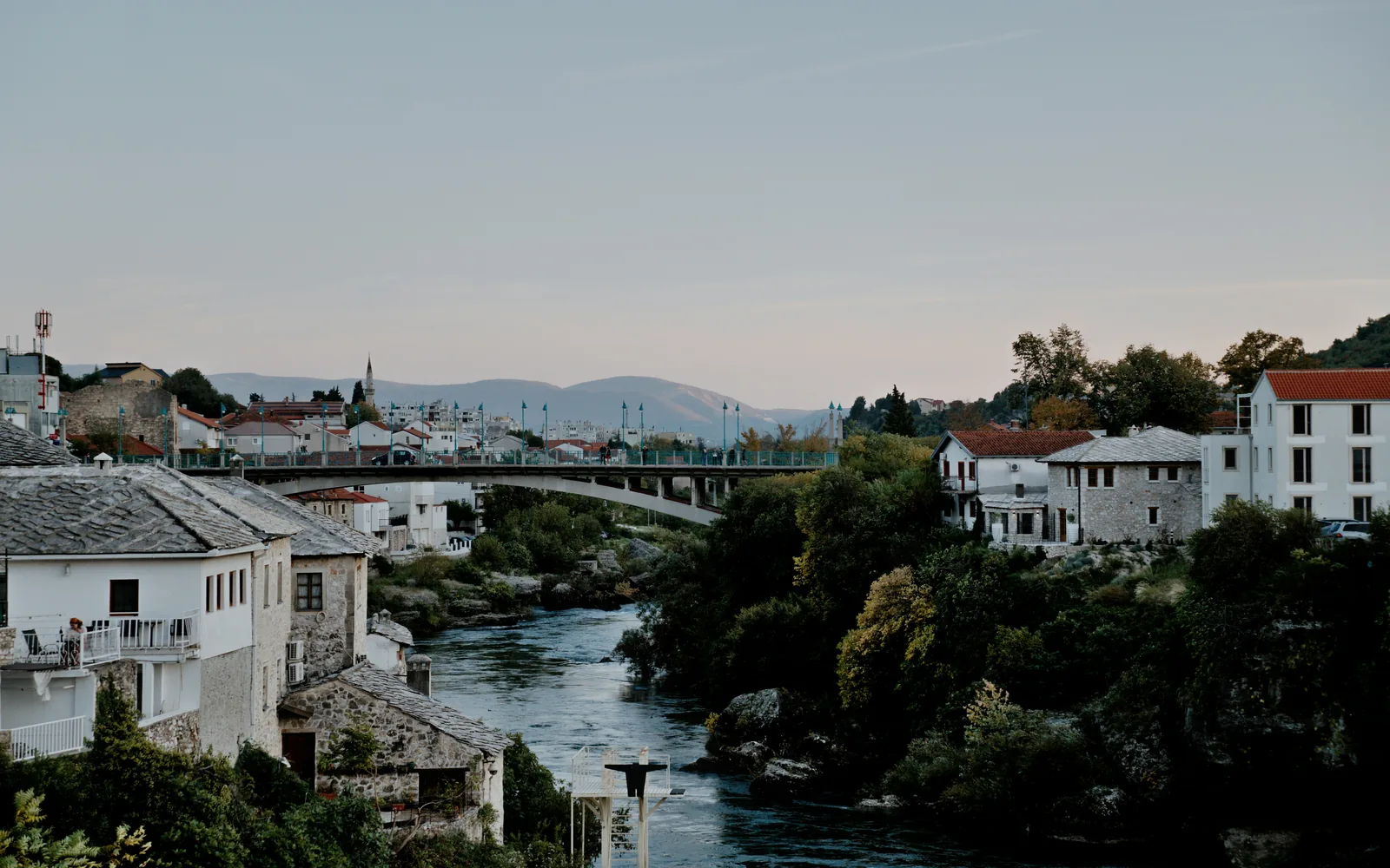 River flows through a european town with old buildings.