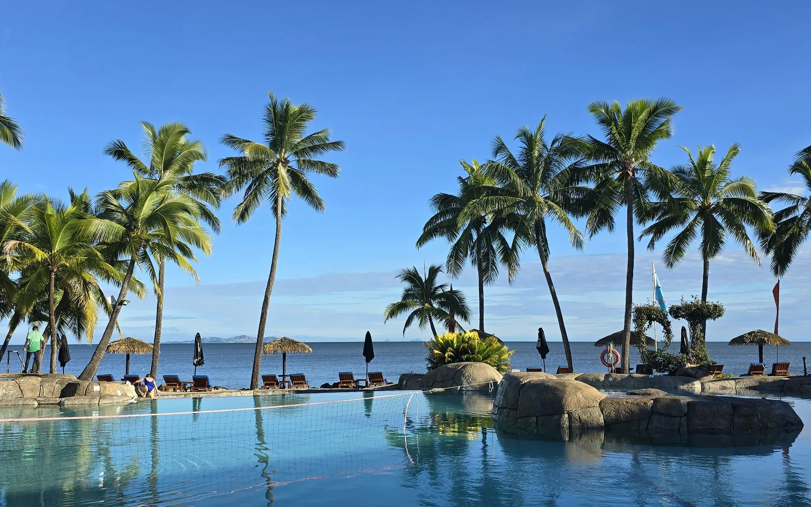 Palms over a pool blue with tropical ocean, a perfect travel destination -Fiji