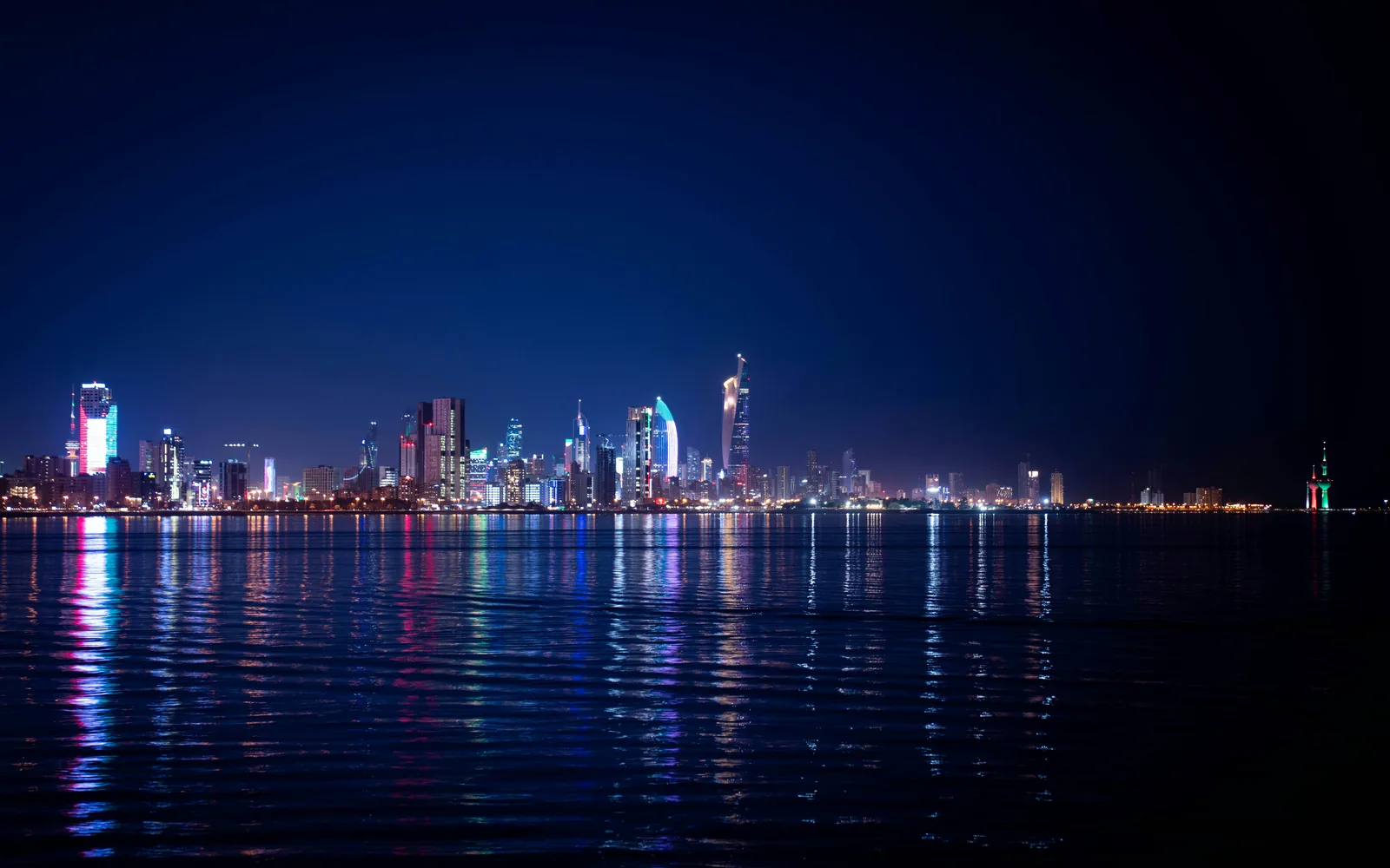 City skyline illuminated at night with water reflections
