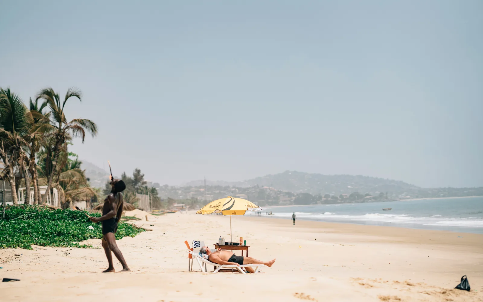 Beach scene with fire eater and tourist in Lumley Beach, Freetown