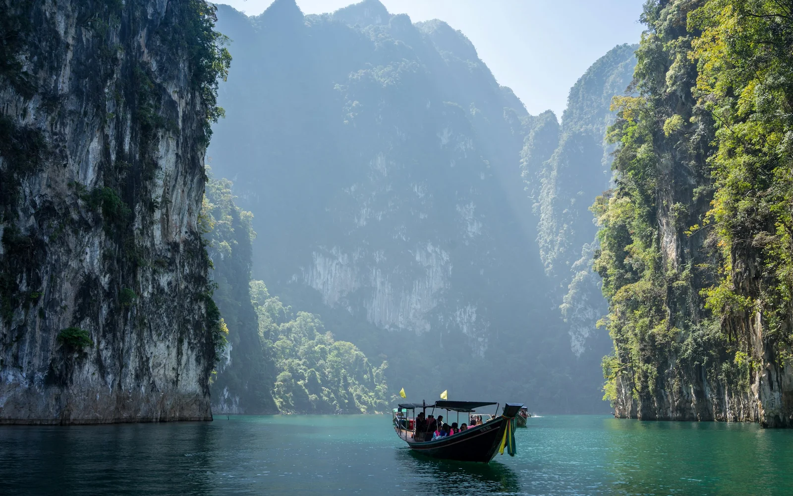 White longtail boat between rocky karst mountains, Khao Sok, Thailand
